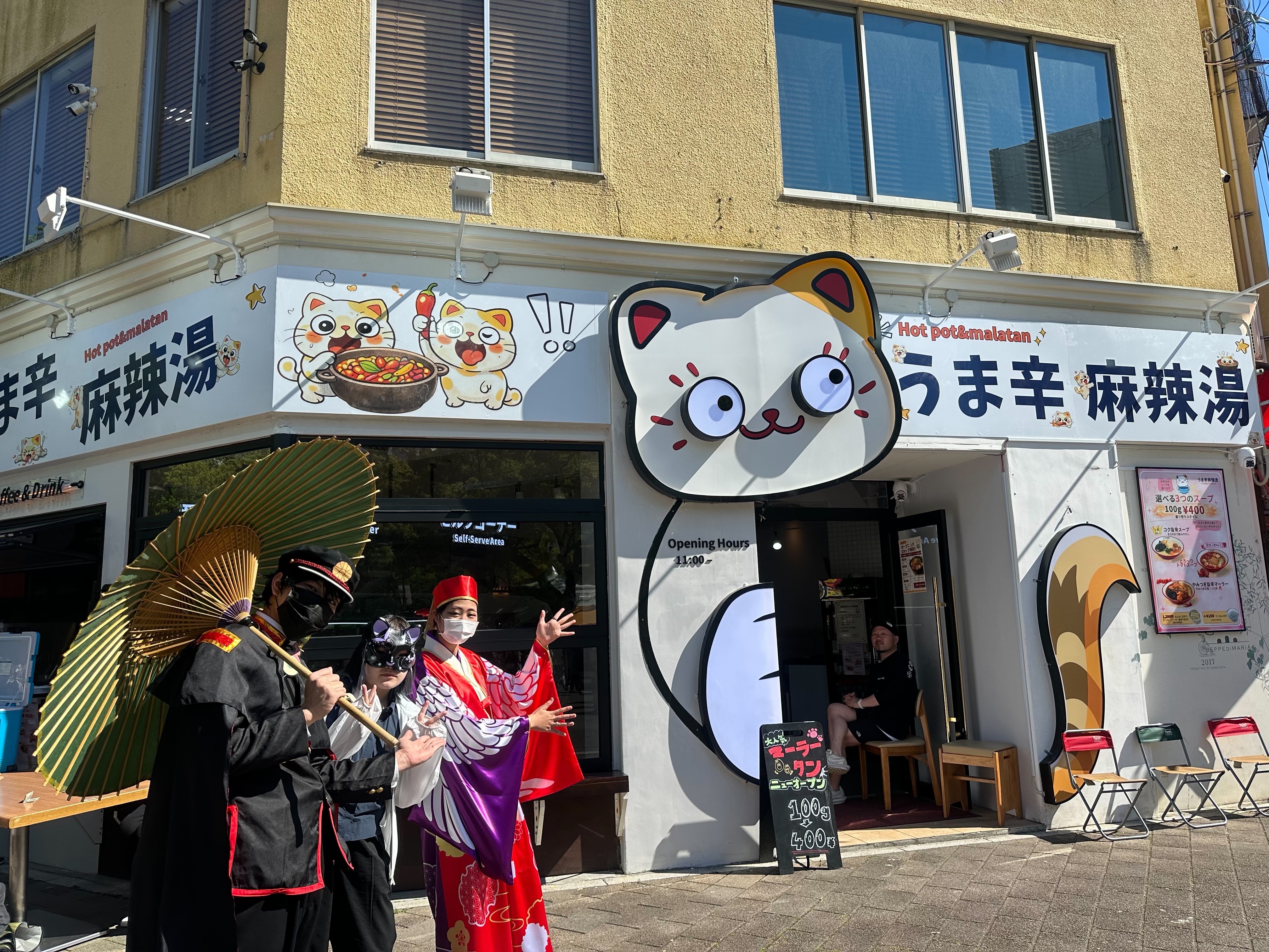 赤いのれんの奥に客席が続き、壁に猫のキャラクターの掲示が見える店内写真